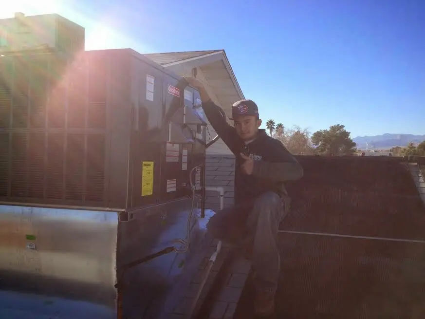 HVAC technician performing AC Tune-Up on a rooftop unit in Gridley