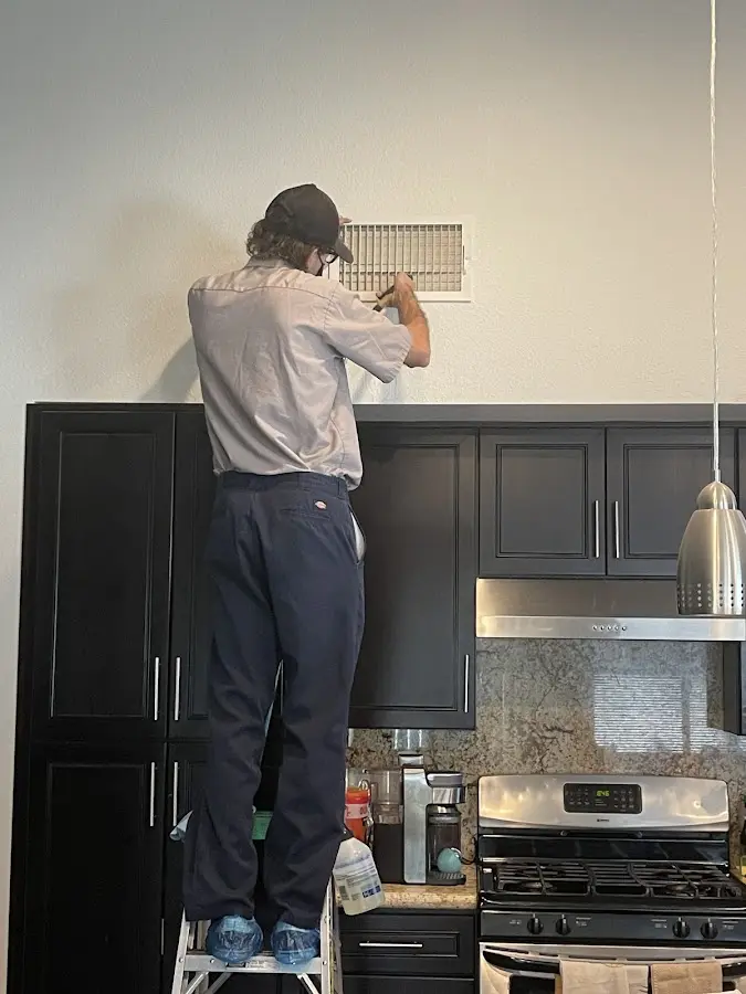 Technician inspecting an air vent during HVAC service in Gridley